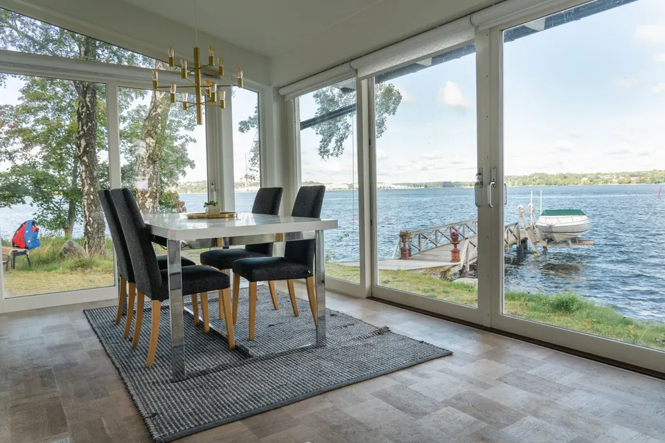 The bright dining area surrounded by water-facing windows